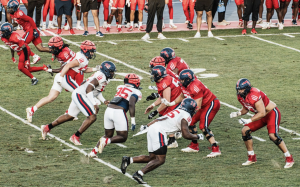 FAU’s Red and White teams running towards each other in the 2025 Spring Football Game.
